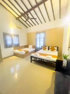 a large room with two beds in it at Chrish Residence in Negombo
