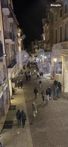 a group of people walking down a street at night at la promenade in Vicenza