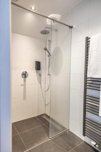a shower with a glass door in a bathroom at Het Maashotel in Broekhuizen +71 photos