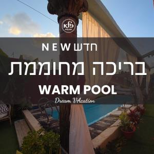 un panneau sur un poteau à côté d'une piscine dans l'établissement פלא - PELEH -KASHMIR -Quiet place 3 km from caesarea beach, à Or ‘Aqīvāh