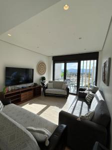 a living room with couches and a flat screen tv at Ayla golf luxury chalet in Aqaba