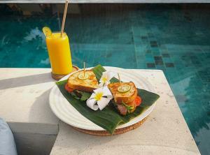 a plate of food on a table next to a drink at Gila House - Adults only in Gili Islands