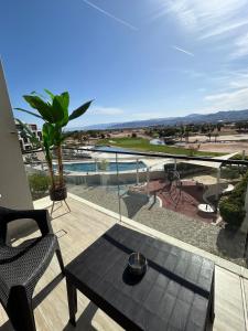 a balcony with a table and a view of a pool at Ayla golf luxury chalet in Aqaba