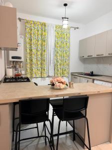 a kitchen with a counter with two chairs and a table at Studio Militari Residence in Roşu +4 photos