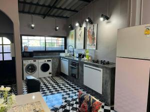 a kitchen with a sink and a washer and dryer at Nong Hoi house in Ban Nong Chaeng