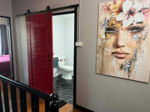 a bathroom with a painting of a woman with a toilet at Nong Hoi house in Ban Nong Chaeng +8 photos