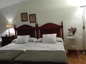 um quarto com uma cama grande e 2 almofadas em Casa De Grande em Cambados