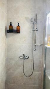 een douche met een douchekop in een badkamer bij Boulevard apartament in Sighetu Marmaţiei