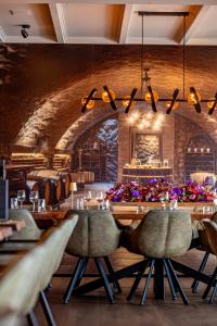 a dining room with a long table and chairs at Het Maashotel in Broekhuizen