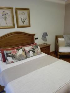 a bedroom with a large white bed and a chair at Casa De Grande in Cambados