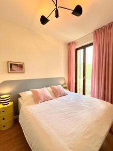 une chambre avec un grand lit blanc avec des oreillers roses dans l'établissement Atelier Noé NOIR - Kunstvoll Wohnen - Wunderbares Frühstück möglich - Ruhig und nah am Zentrum -, à Chemnitz 22 autres photos