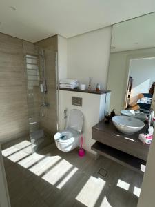 a bathroom with a toilet and a sink at Ayla golf luxury chalet in Aqaba