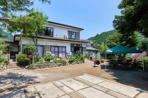 a house with a table and an umbrella in front of it at Sagamihara - House - Vacation STAY 15450 in Toya