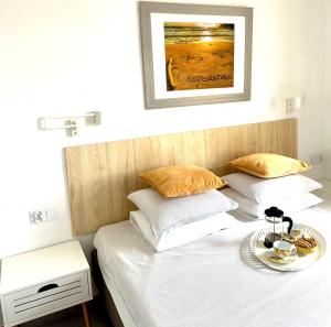 ein Bett mit zwei Kissen und einem Tablett darauf in der Unterkunft PAOLA Comfort Apartment in Costa Calma + 26 Fotos