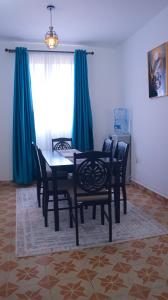 Un comedor con mesa y sillas y una ventana. en Rehema Apartments, en Kisumu