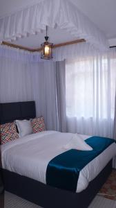 Un dormitorio con una cama y una lámpara de araña en Rehema Apartments, en Kisumu