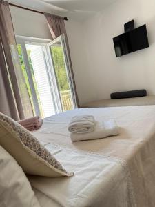 a bedroom with a bed with a large window at Rose rooms on the island of Rab in Rab