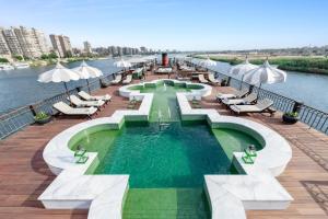 a pool on a cruise ship with chairs and umbrellas at Movenpick SS Misr Steamer Nile Cruise - 04 & 07 Nights Each Monday From Luxor and 03 Nights Each Friday from Aswan in Luxor