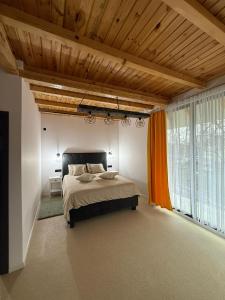 a bedroom with a bed and a large window at Zen Resort and Winery in Slănic