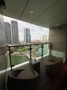 ein Balkon mit zwei Stühlen und Blick auf die Stadt in der Unterkunft Cinnamon Life Residencies- Luxury 2 Bedroom Apartment 18th Floor in Colombo + 32 Fotos