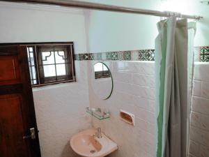 a bathroom with a sink and a mirror at Scarlets Inn in Cochin