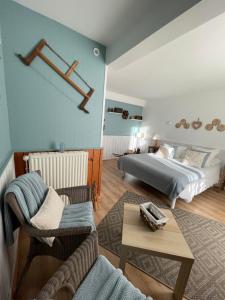 a bedroom with a bed and a couch and a table at Auberge du Col de Néronne in Le Falgoux