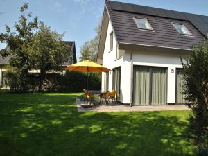 - une table et des chaises sous un parasol dans la cour dans l'établissement Great holiday home energy neutral on Texel with sauna and sun shower, à Westermient 32 autres photos