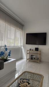 a living room with a flat screen tv on a wall at Relax on the Beach in Guarujá