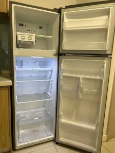 米里BS Homestay1 - 1 Bedroom Apartment in Miri Times Square的厨房里有一台空冰箱，门敞开着