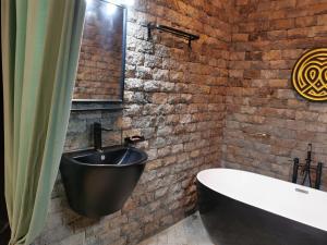 a bathroom with a black tub next to a brick wall at Ibuye Villa Holiday Home in Nyakinama +68 photos