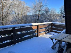 a bench on a fence covered in snow at Chalet am Biggesee in Olpe