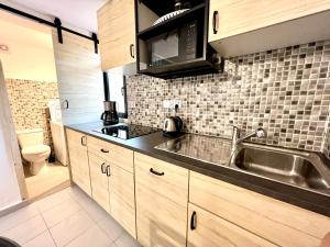 eine Küche mit Spüle und Mikrowelle in der Unterkunft PAOLA Comfort Apartment in Costa Calma