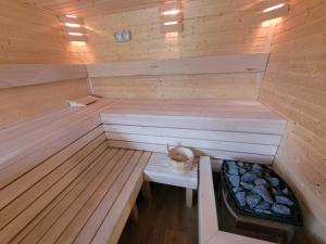 a wooden sauna with a bench in the middle at APANÓWKA domki z balią jacuzzi sauna in Trzebiechowo