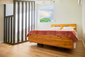 a bedroom with a wooden bed and a window at Écrin d'évasion in Sainte-Anne