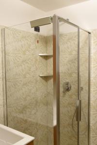 una doccia con una porta in vetro in un bagno di Appartamento Margherita a Panchia