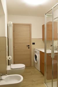 un bagno con un lavandino del water e una lavatrice di Appartamento Margherita a Panchia