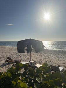 a beach with chairs and an umbrella on the sand at Ribera Del Norte Bungalows in Canoas +124 photos