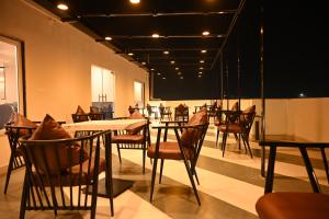 jadalnia ze stołami i krzesłami oraz czarną ścianą w obiekcie The Regal Crown By Ritya Hotels w mieście Ayodhya