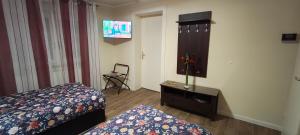 - une chambre avec un lit, une commode et une télévision dans l'établissement Die Hotelalternative Michael Treiber 5, à Solingen