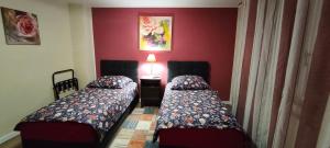 - 2 lits dans une chambre aux murs rouges dans l'établissement Die Hotelalternative Michael Treiber 5, à Solingen