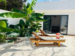 a chair sitting on the sand in front of a house at U PARADISU VILLAS - Private Pool in Jambiani