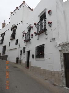 a white building with flower boxes and windows at Capricho Azul in Conil de la Frontera