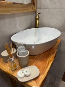 a white bowl sink on a wooden table in a bathroom at Pensiunea Roua Brazilor Mărișel in Mărişel +30 photos