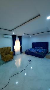 Un dormitorio con una cama, un sofá y una silla. en Trinity Apartments, en Lekki