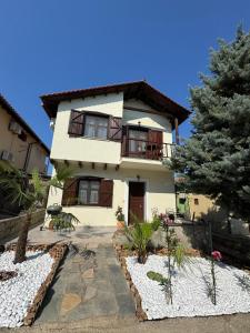 a large white house with a tree in front of it at Palm Villa in Skala Sotiros