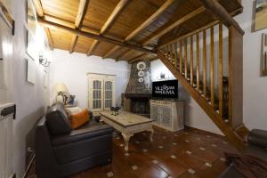 a living room with a couch and a fireplace at Villa Monte Domingos Simoes in Sesmarias