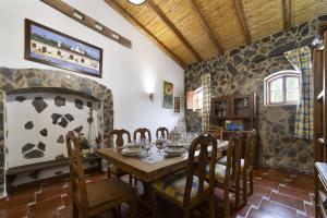 a dining room with a table and a stone fireplace at Villa Monte Domingos Simoes in Sesmarias