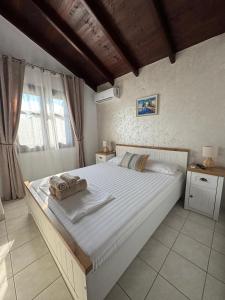 a bedroom with a large bed with towels on it at Palm Villa in Skala Sotiros