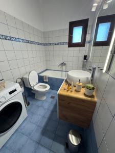 a bathroom with a toilet and a sink and a tub at Palm Villa in Skala Sotiros