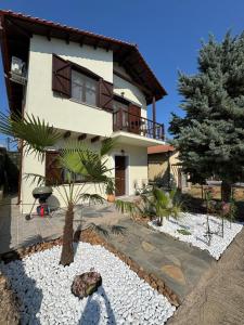 a house with a palm tree in front of it at Palm Villa in Skala Sotiros